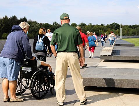 A man standing next to a couple with one of them in a wheelchair