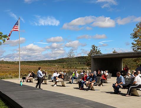 A plaza with an American flag and parents sitting on benches