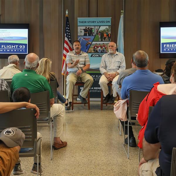 Two people speaking to a room full of people