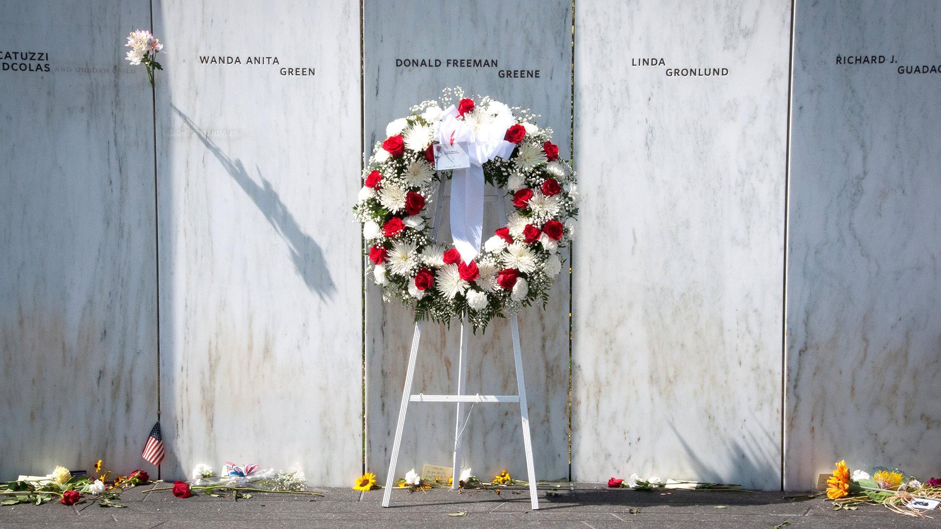 A flower wreath in front of the memorial wall