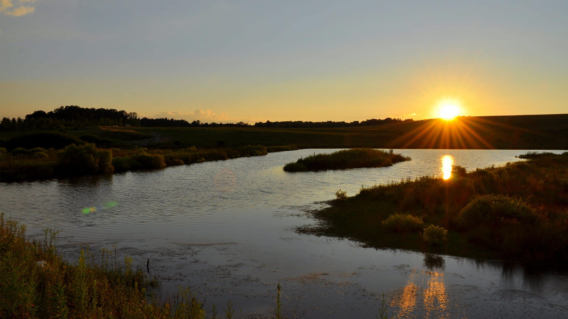 a sun setting over a body of water