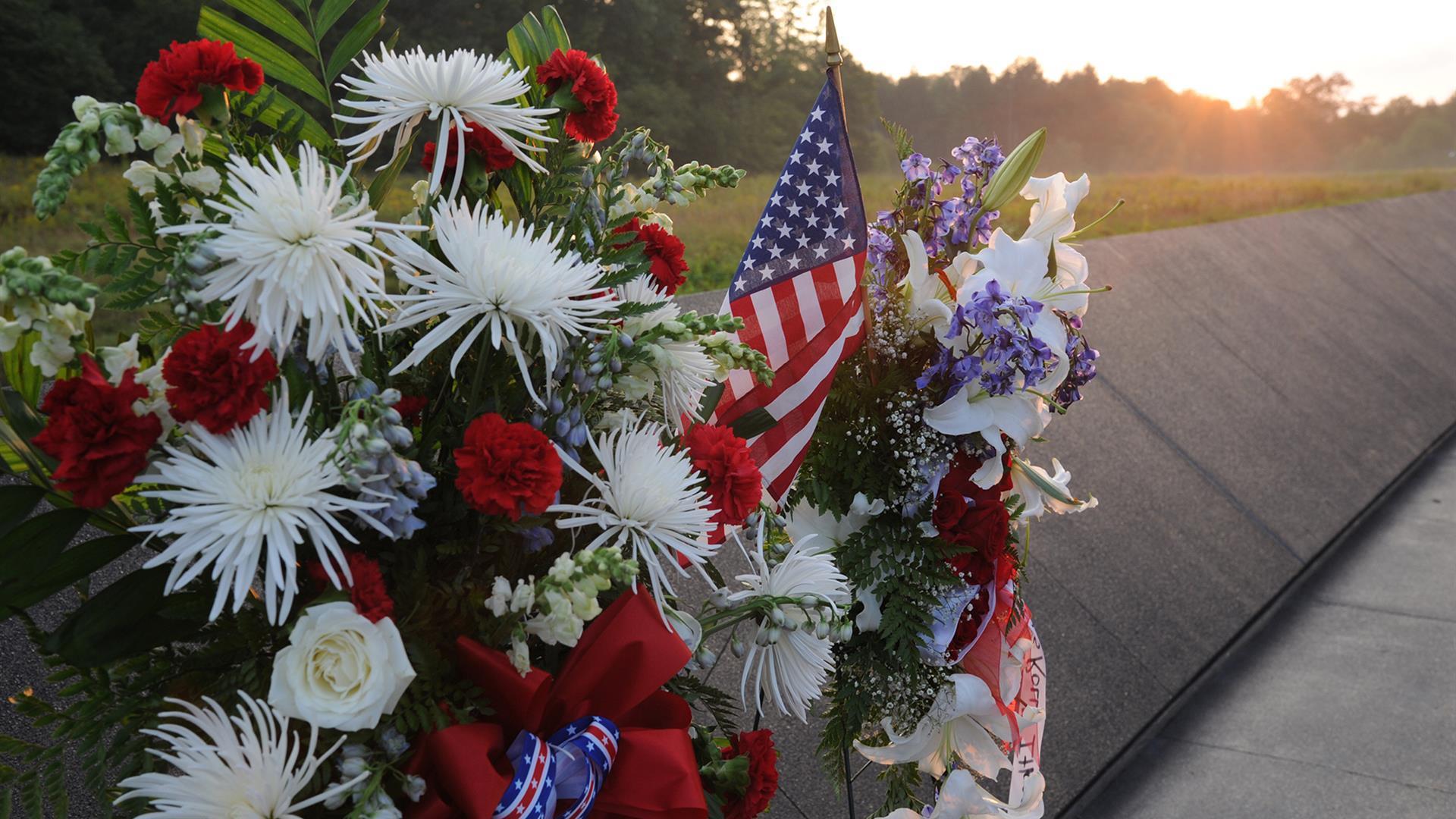 a flower bouquet with an American flag and a sunset in the background